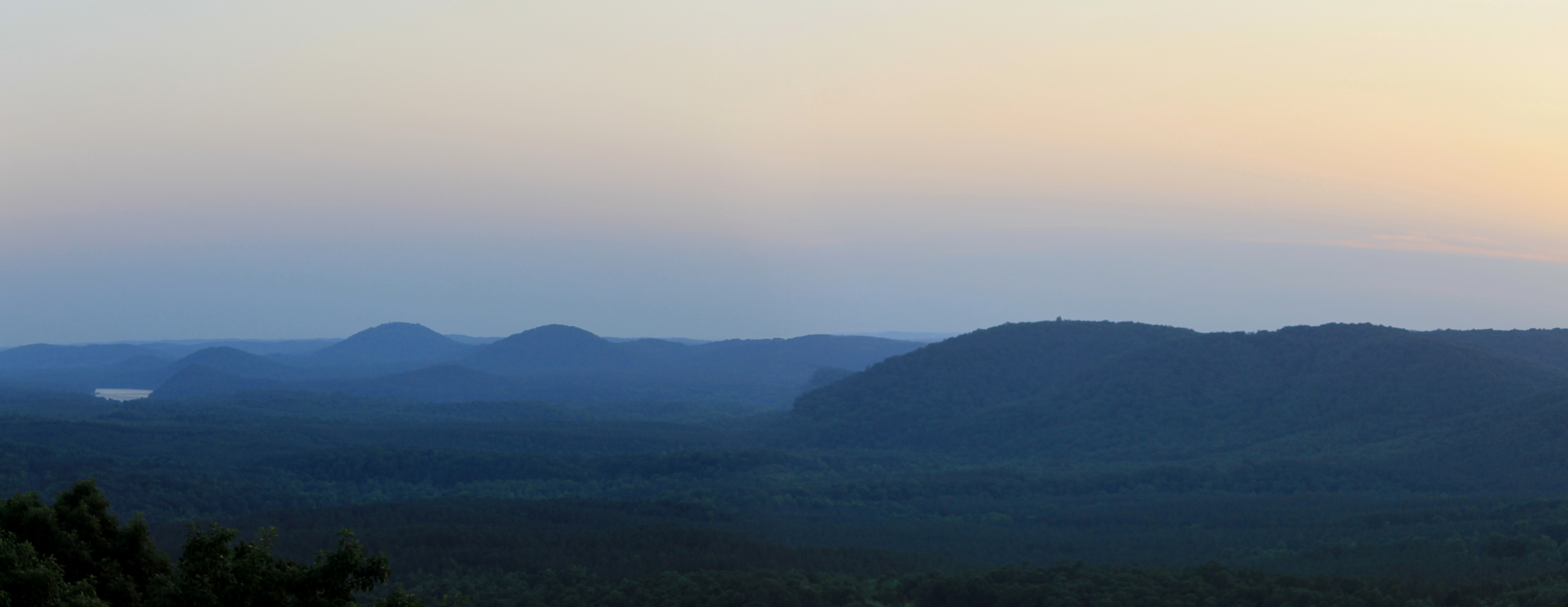 Panoramic view from the peak of Morrow Mountain State Park. Sky is a dusty pink color. 